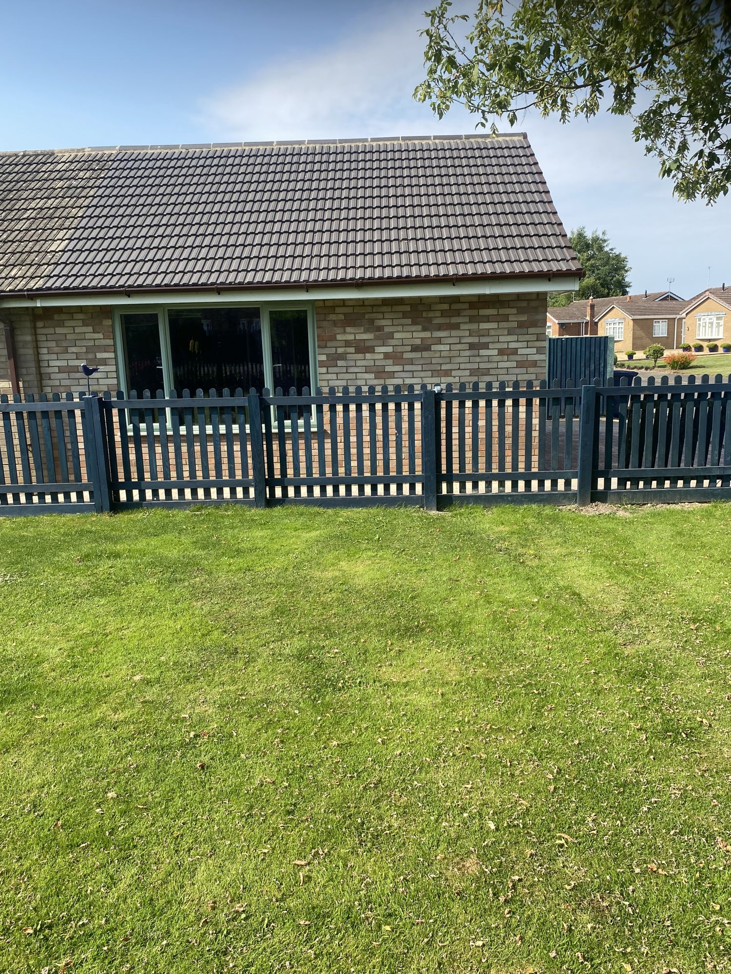 Bungalow with new painted picket fencing and lawn
