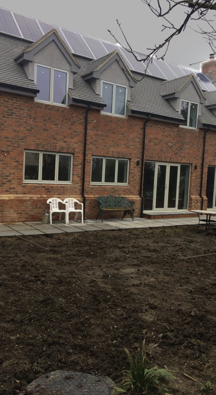 Rear of a finished detached brick home with four dormers and a solar roof